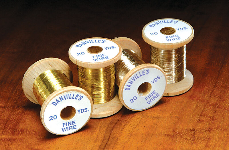 Four wooden spools of Danville's Fine Wire in gold and silver tones, used for detailed fly fishing tackle and rod building applications.