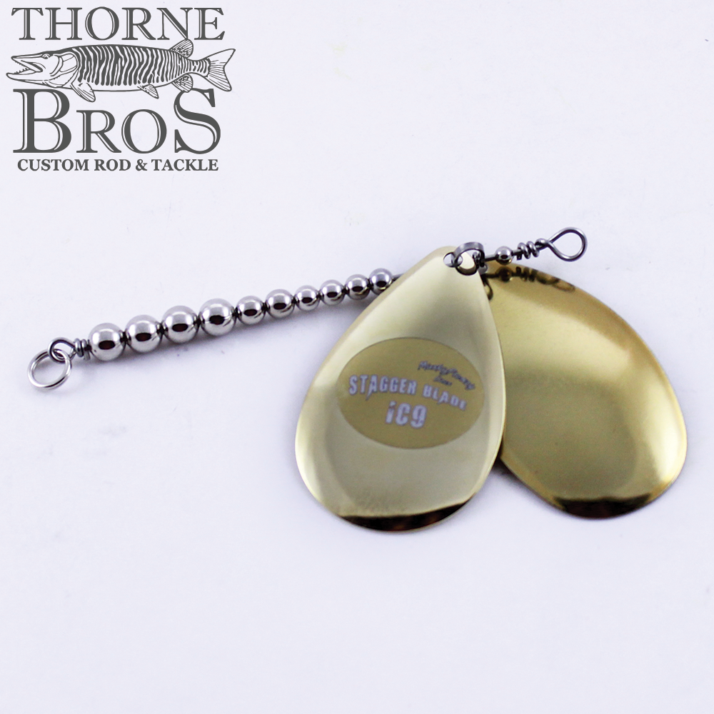 Musky Frenzy Blade Attachments featuring two shiny brass-colored staggered blades connected by a beaded wire, designed for enhancing fishing tackle and lure action.